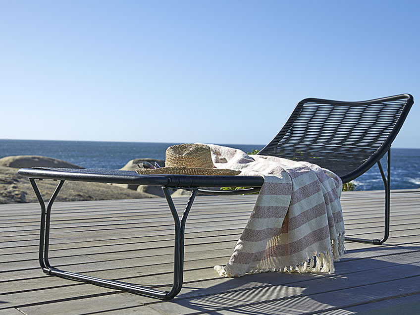 UBBERUP sun lounger and AMASONLILJE throw Sun lounger on a wooden patio by the ocean