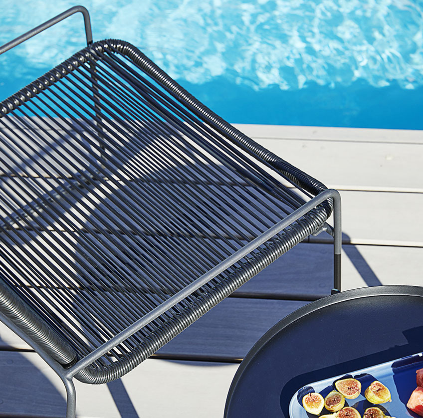 BANDSBJERG lounge chair and BORRE side table Pool chair and side table on a sunny patio