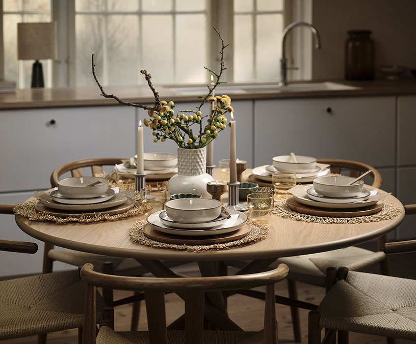 SKIBET dining table with FERDUS plates and bowls, GERVIG drinking glasses and INGBERT vase Round dining table set for a birthday dinner with vase, plates, bowls, glasses and candles