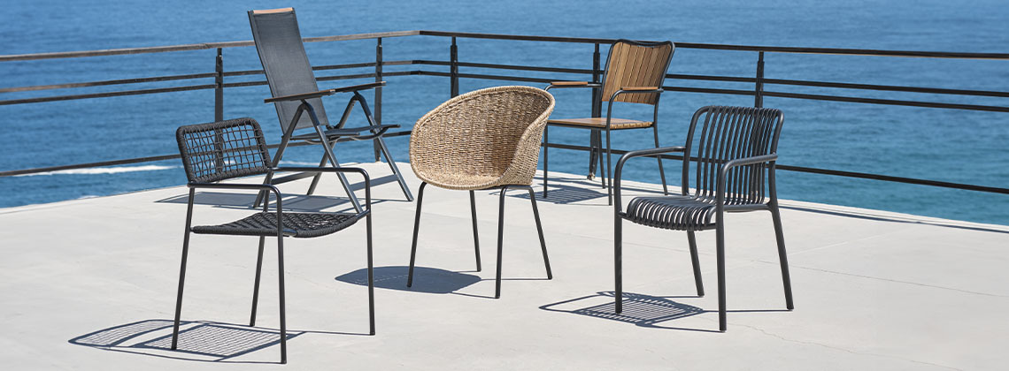 From left: LABING, BREDSTEN, TUERNE, BASTRUP, and NABBEN garden chairs A selection of five garden chairs on patio by the sea