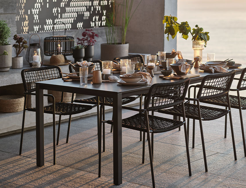 LANGET garden table and LABING garden chairs Garden table and garden chairs with table set for dinner on patio by sunset