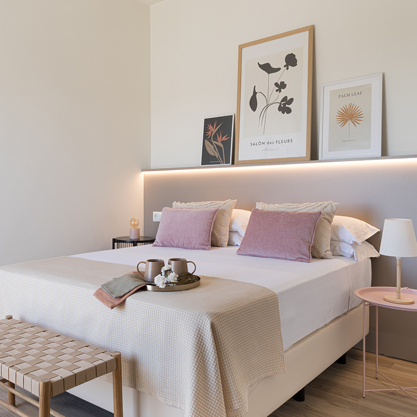 Furnished bedroom with bed, bench and decor.