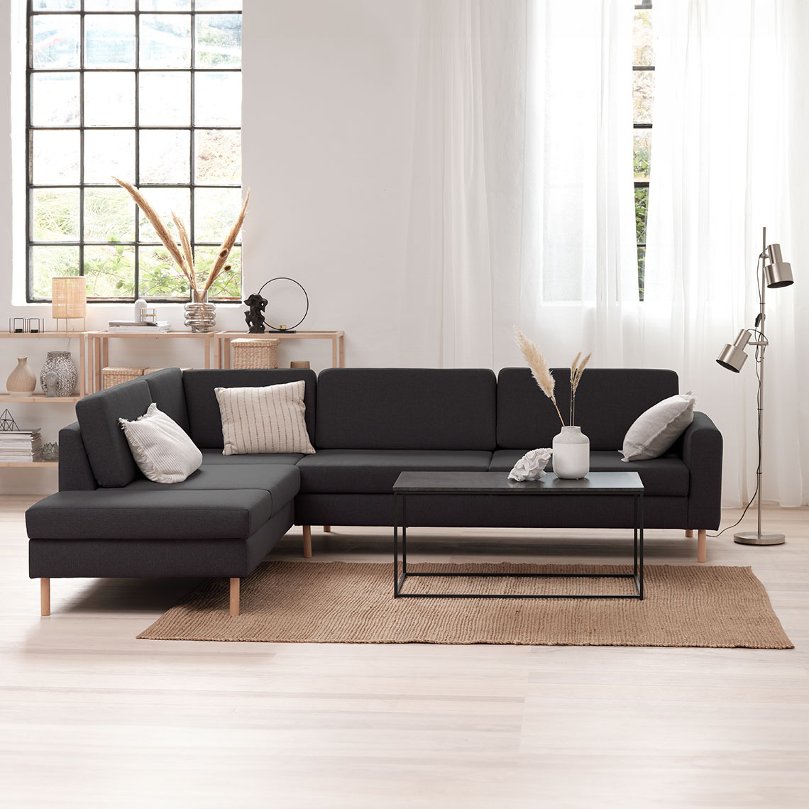 SVALBARD open-end sofa Dark grey corner sofa in a light and airy room with a coffee table and a floor lamp