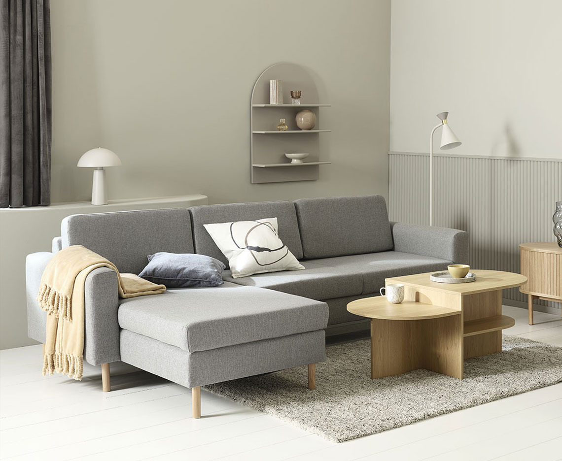SVALBARD chaise longue sofa Grey chaise longue sofa in a living room with coffee table, lamps, and home decorations