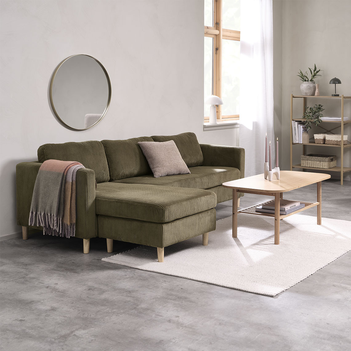 FALSLEV chaise longue sofa Olive green chaise longue sofa with a coffee table and a colourful throw and cushion