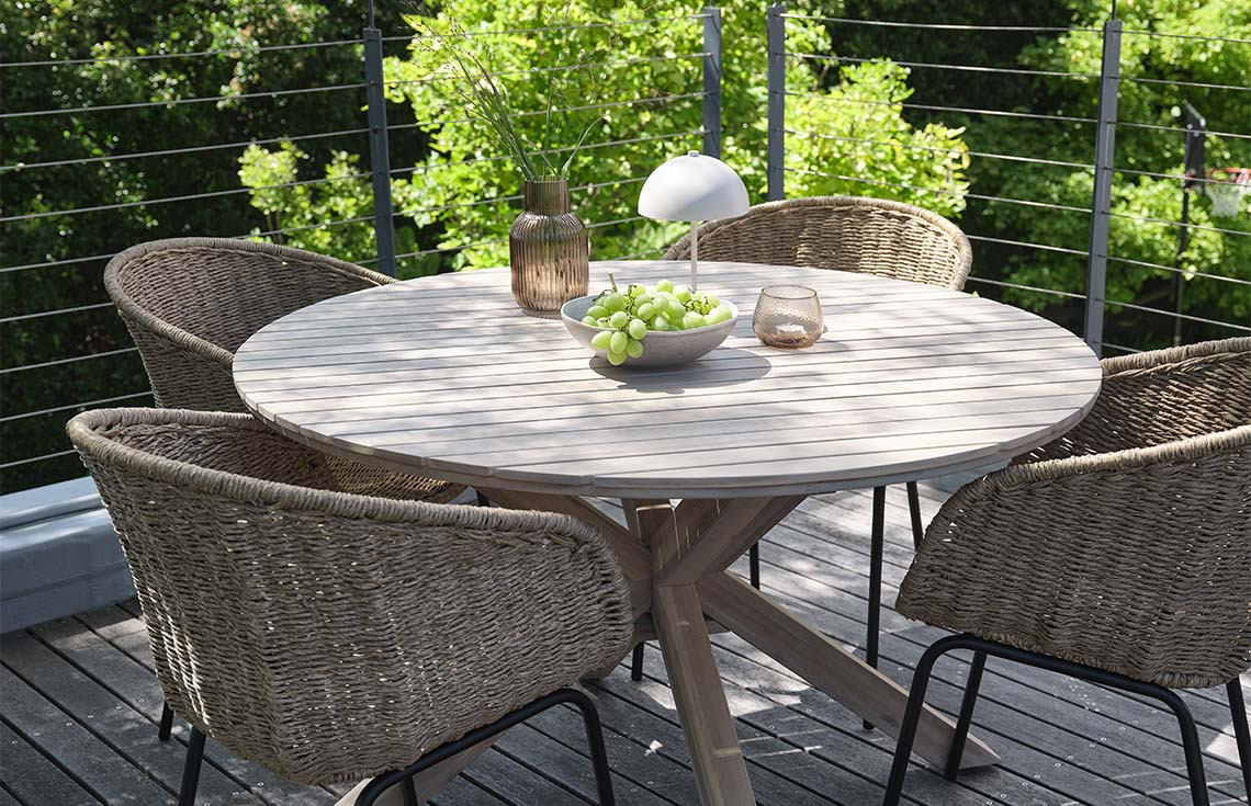 FUGLSAND solid acacia garden table and TUERNE polyrattan garden chairs Garden table made from solid acacia on patio with garden chairs made with polyrattan and steel