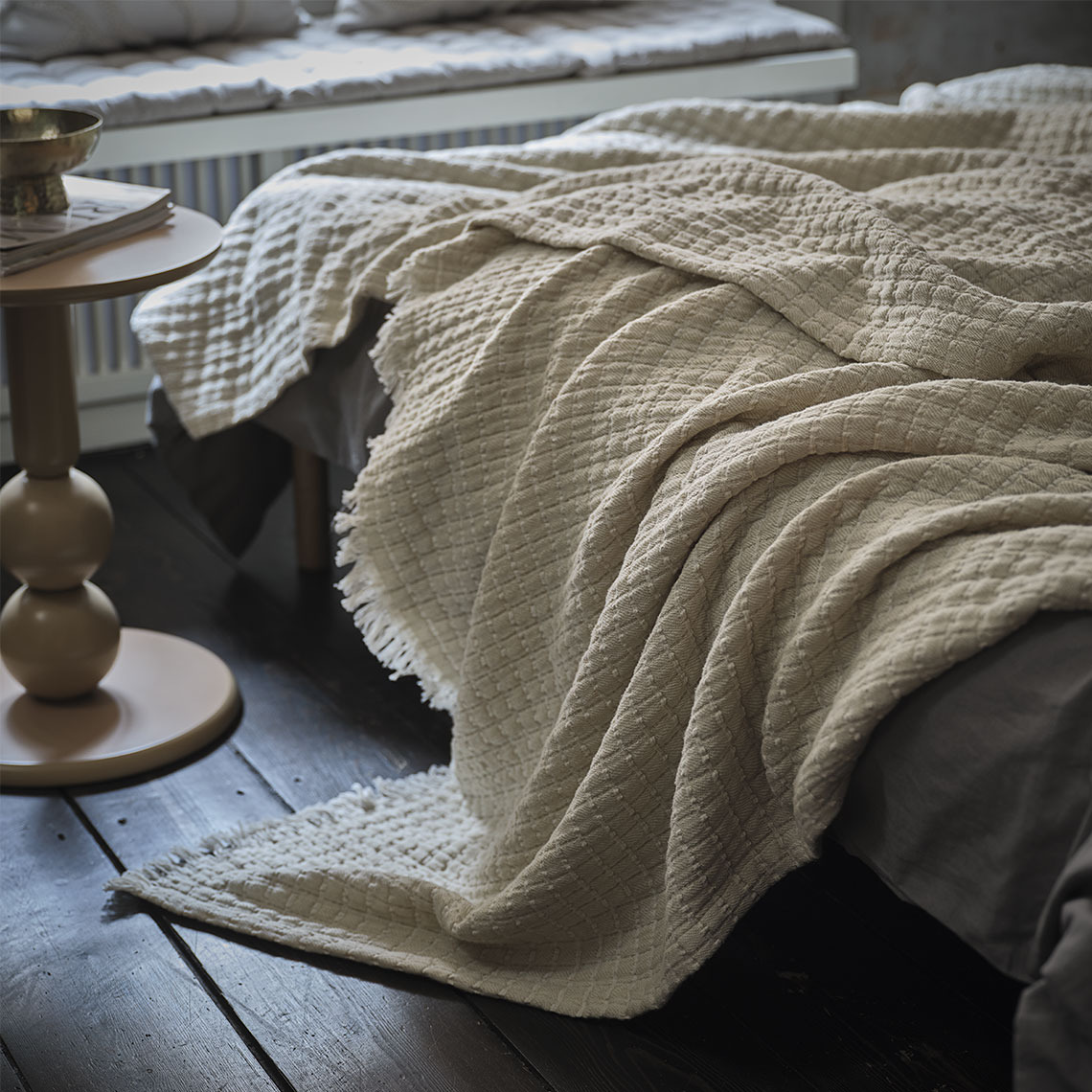 DVERGSYRE throw Beige throw on a bed in a sleeping room