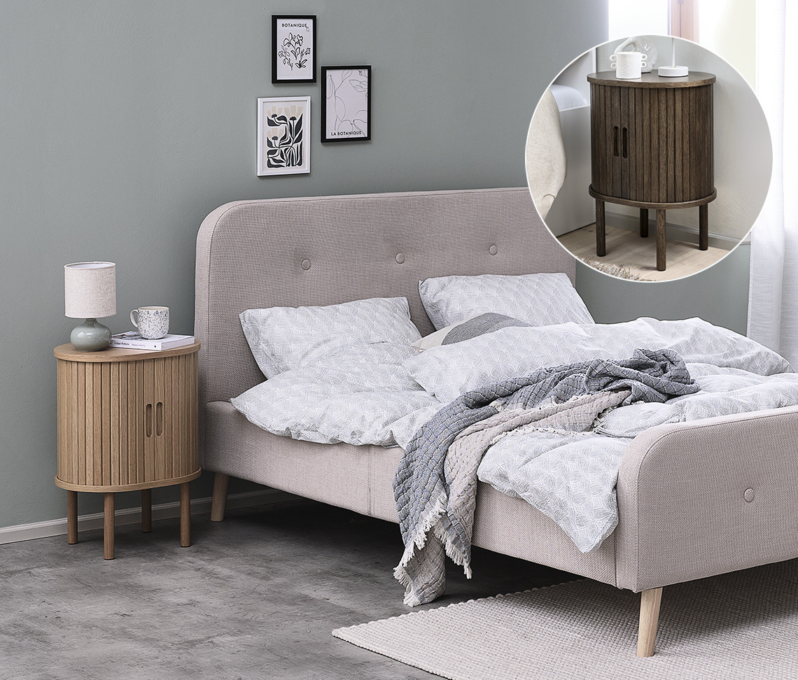 The LYNGVIG bedside table is available in a natural oak and a dark oak version Oak bedside table next to bed in bedroom