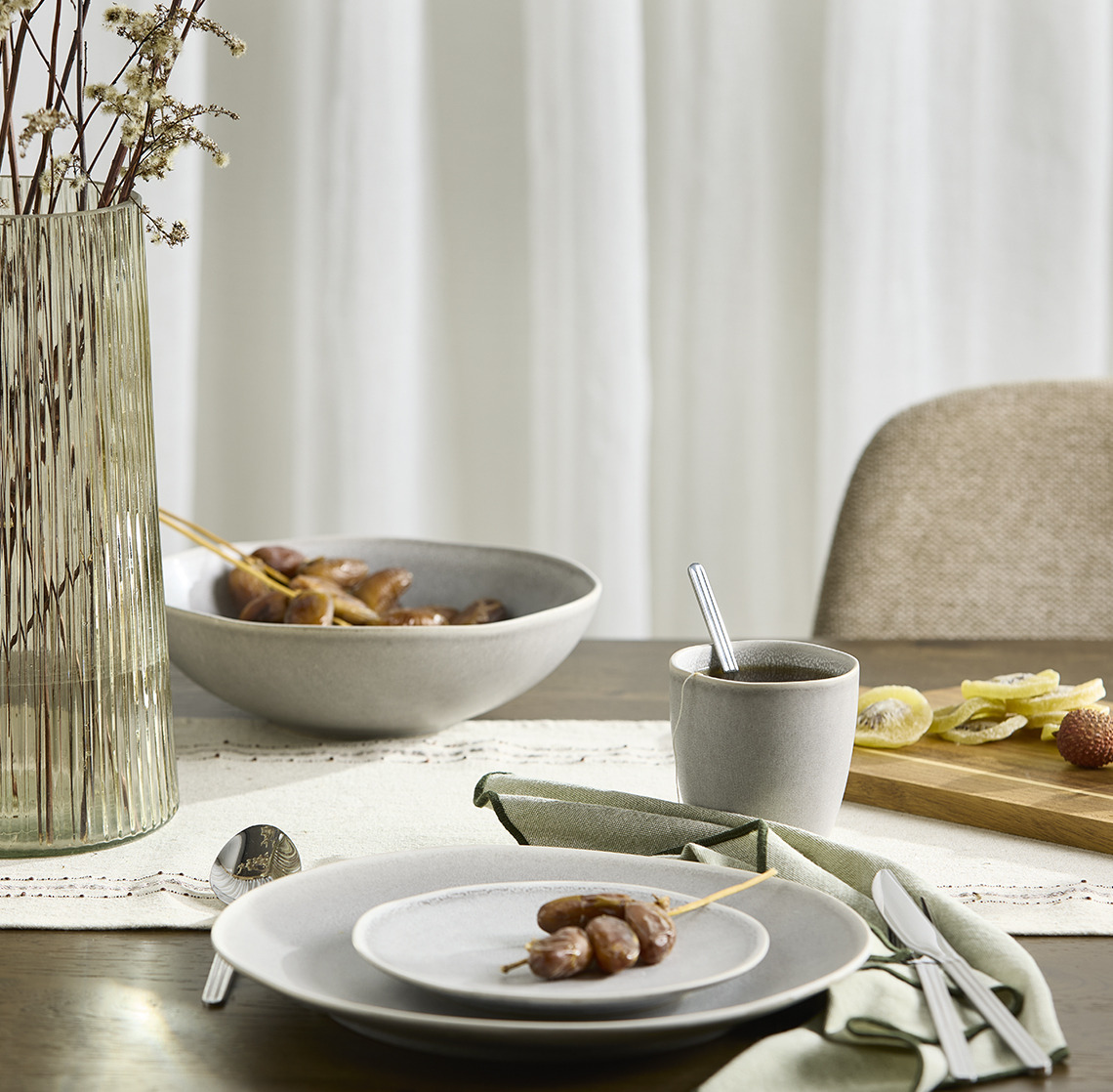 GREGERS cutlery, ELIAS plates, bowl and mug and ROY vase Bowls, plates, a mug and a vase on a dining table