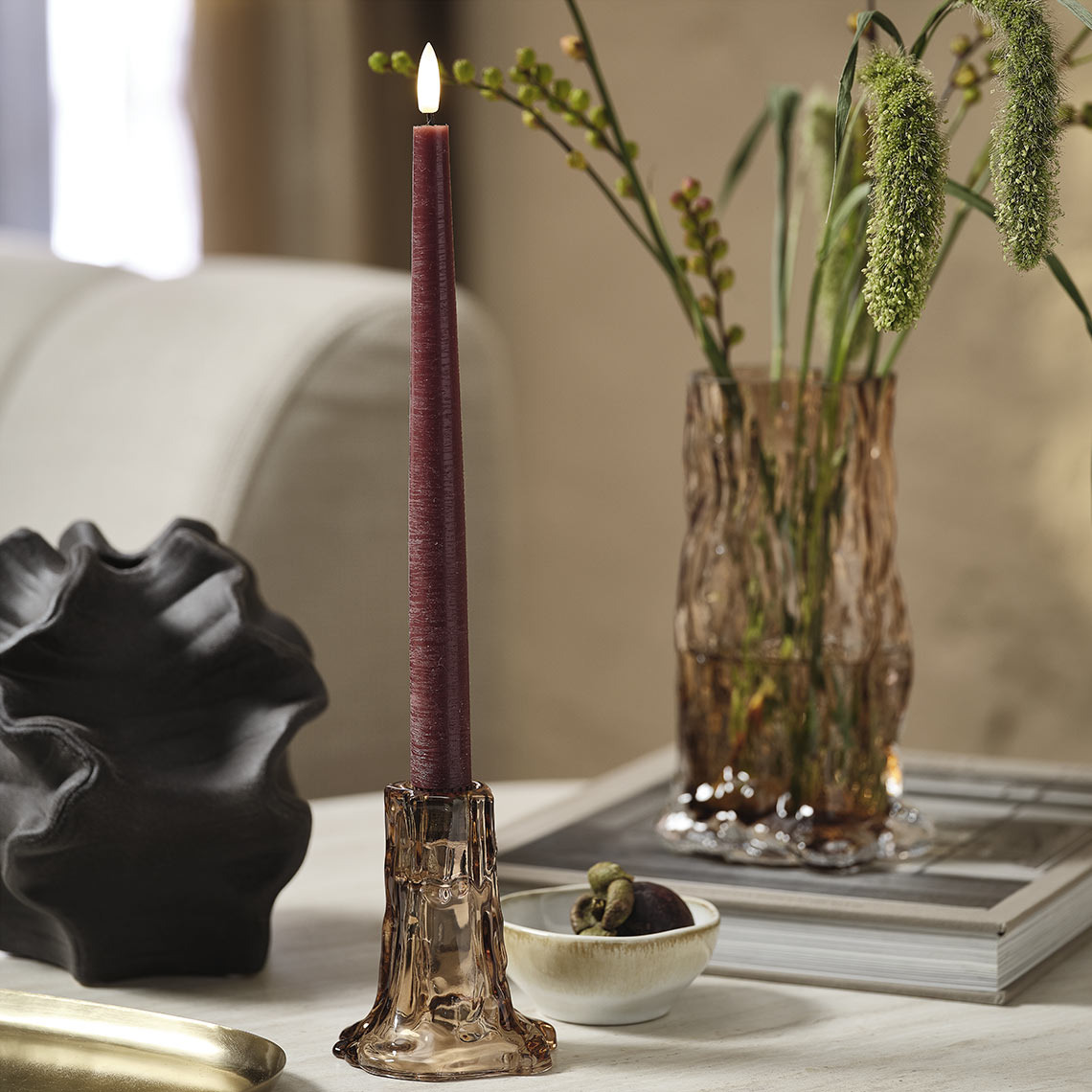 GUDMUND LED candle, VILHELM vase, OTTO glass vase and candlestick, VICTOR bowl Glass vase and candlestick with purple candle on a coffee table