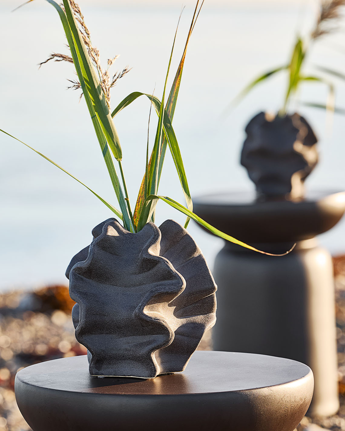 VILHELM vase Organic shape vase on pedestal on a beach