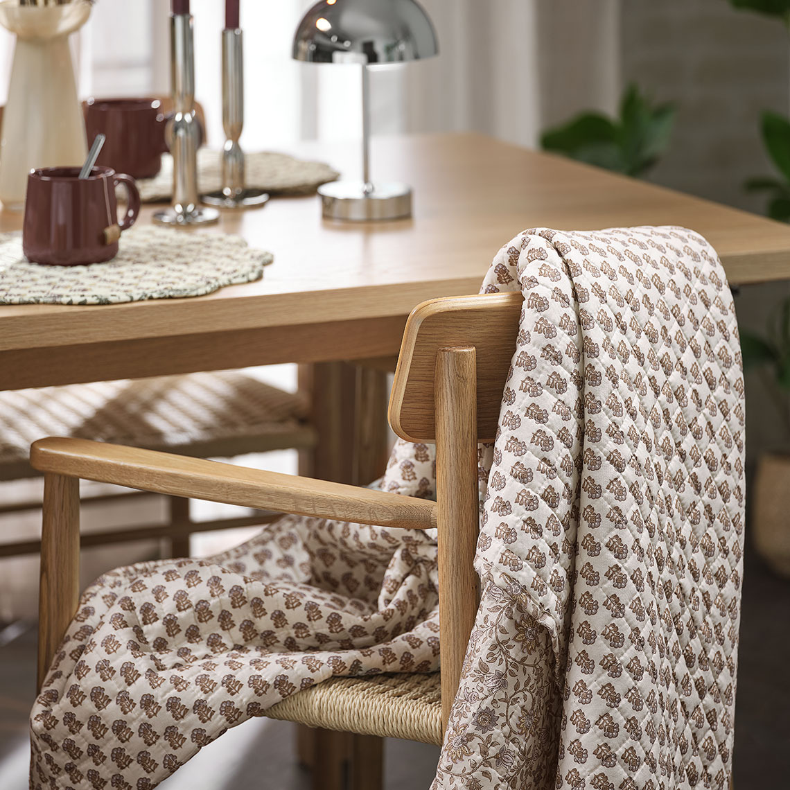 LAVENDEL quilted blanket and ISLEV dining chair Quilted blanket hanging over a dining chair