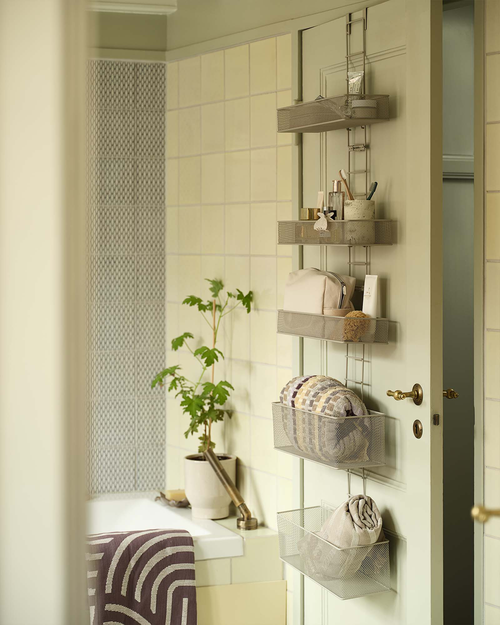 Small bathroom storage with several shelves hanging over a door