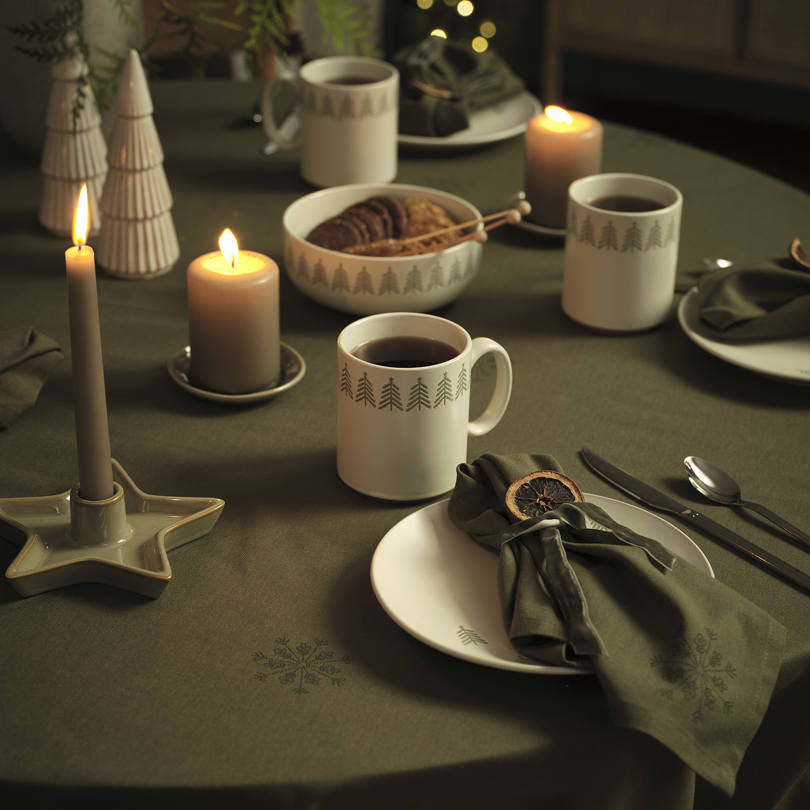 STJERNESTEN tablecloth and cloth napkins, FREKI mugs, plates and bowls, SIF candle holder and MYSING decoration tree Green tablecloth with matching cloth napkins