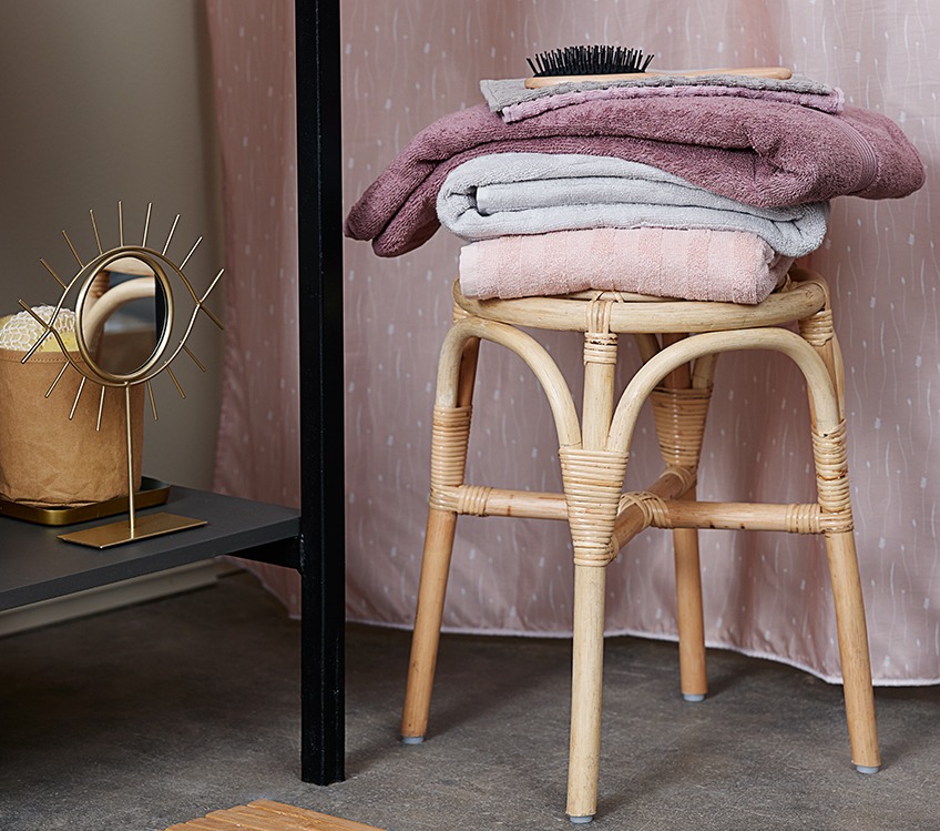 KARLSTAD and TORSBY towels stacked on JUNGSHOLM stool next to DARIUS mirror Towels stacked on a stool next to a decorative mirror