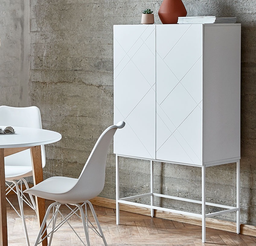 LADBY cabinet with patterned white doors White cabinet with patterned doors in a dining room with white dining chairs
