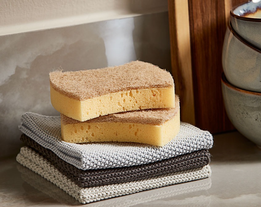 KRILLES cleaning sponge and LOKE dishcloths Dishcloths and cleaning sponges in a stack on a kitchen table