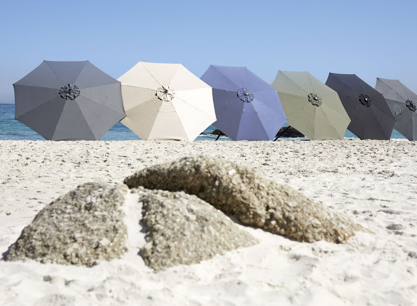 AGGER parasols are available in different colours Parasols in different colours on a beach