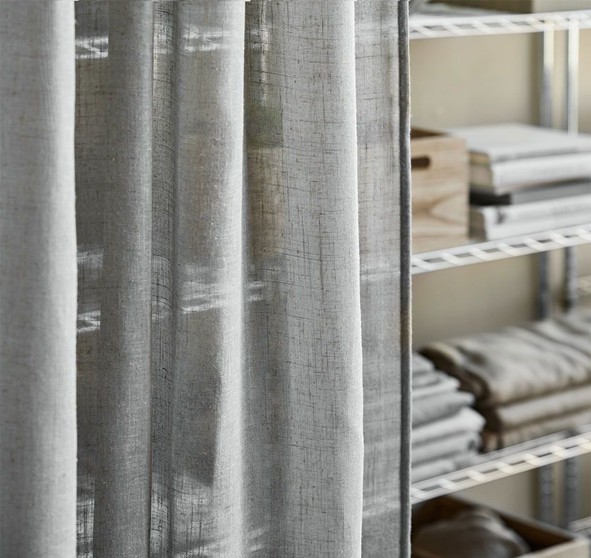AGA linen-look curtain in grey Shelving unit in metal with grey sheer curtains in front
